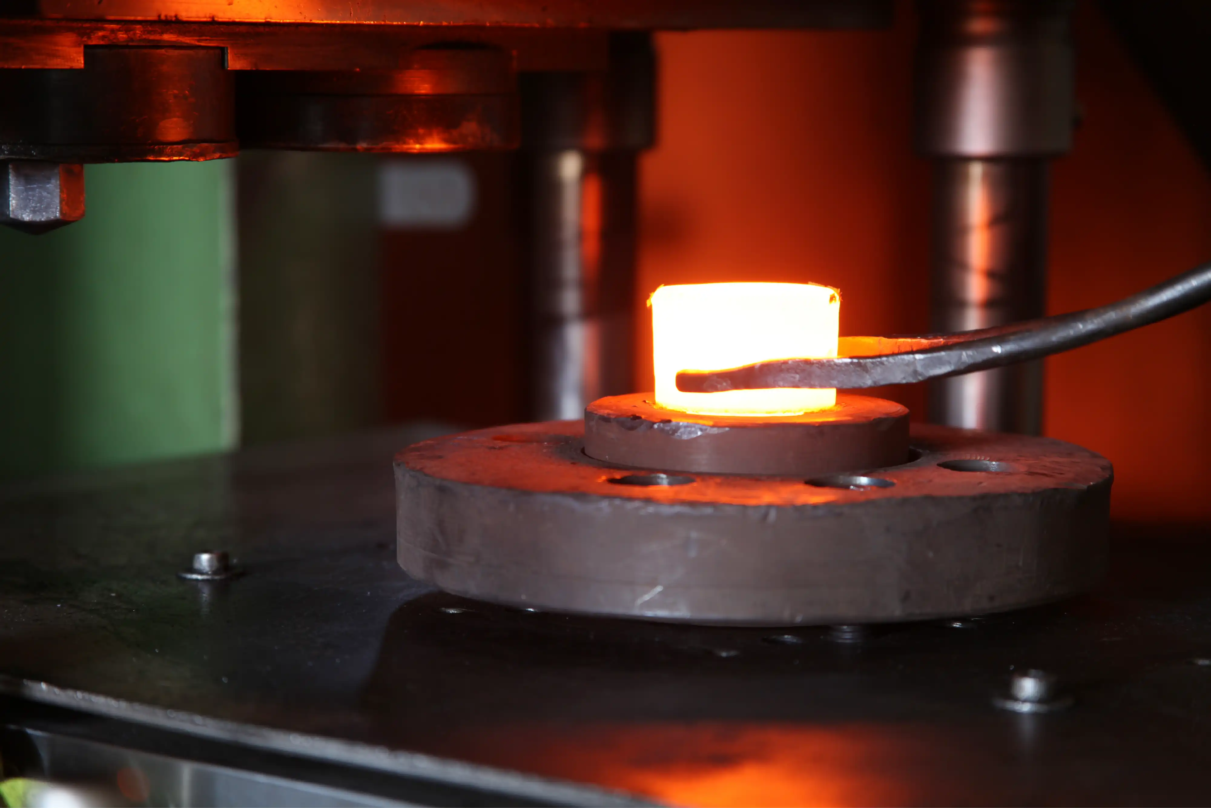 Hot aluminium billet under a forging press in India